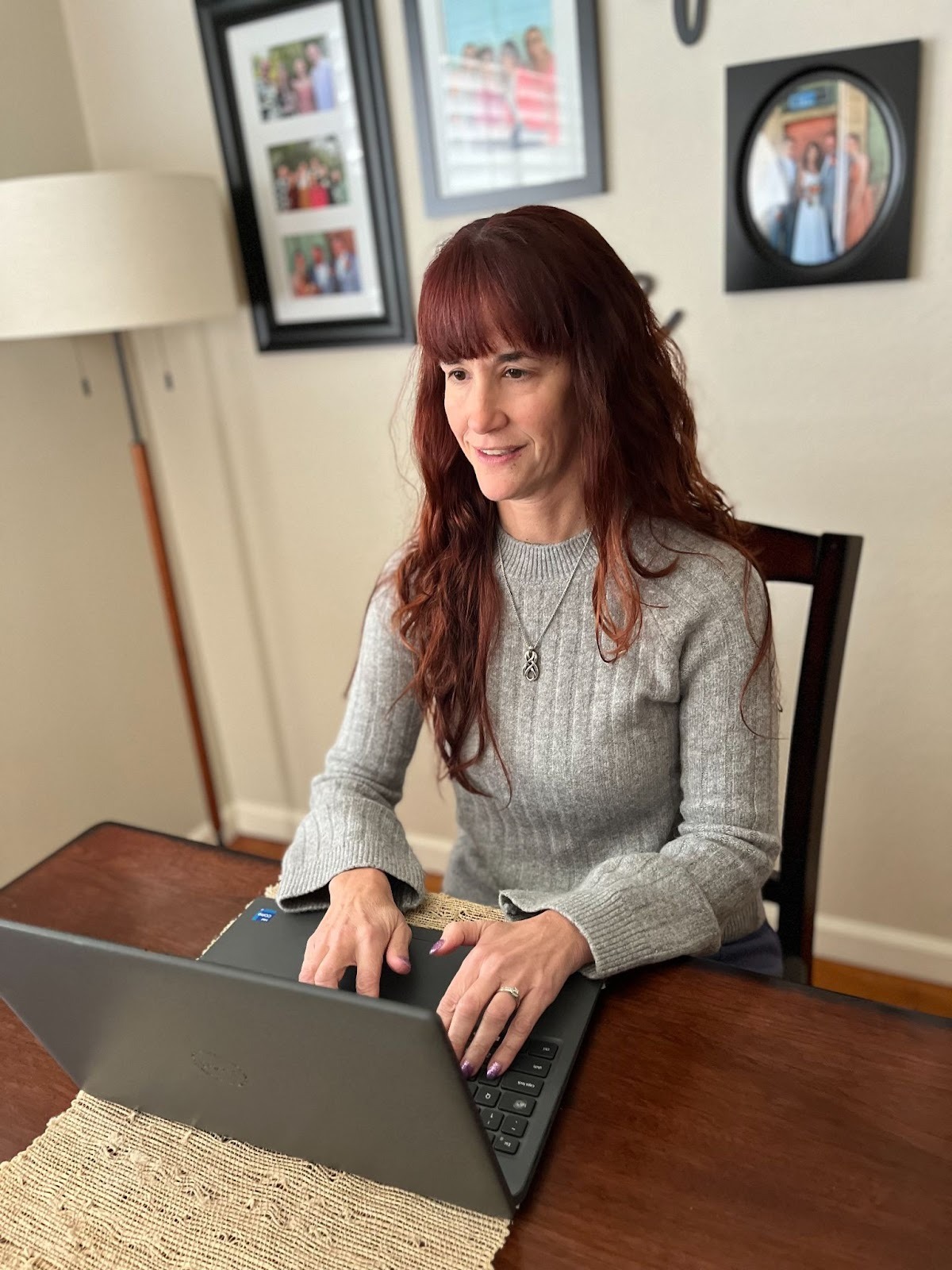 Blind woman with long red hair using her laptop computer.
